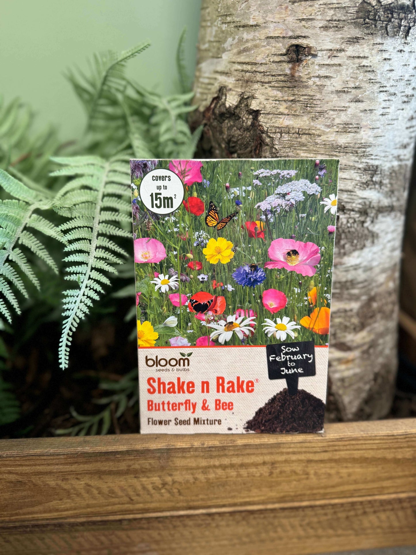 Colourful packaging featuring numerous flower species and butterflies, containing meadow grass seeds.
