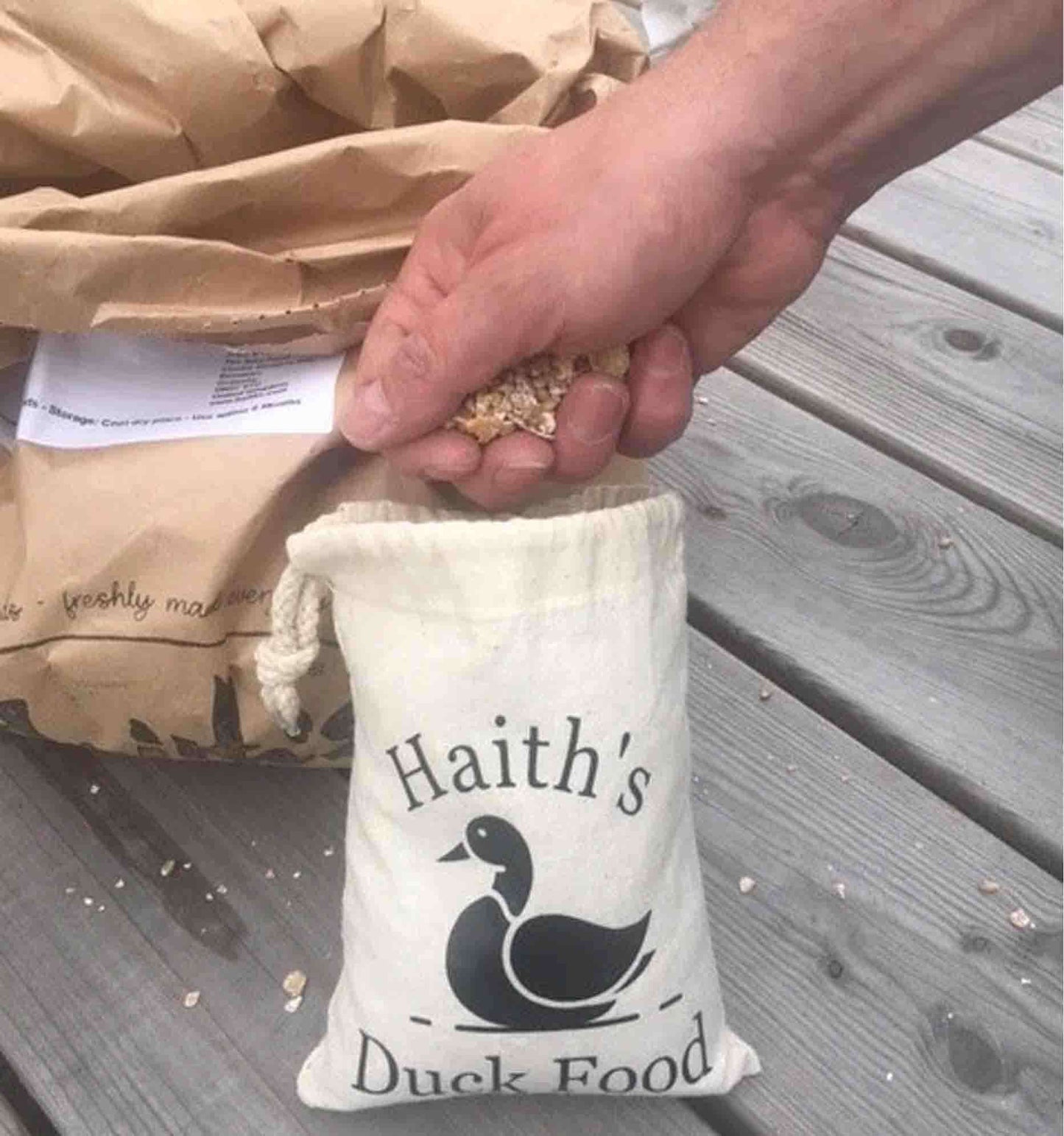 Duck and Goose Mix being taken out of Haith's Duck Food Pouch - a cotton bag with a duck printed on it.